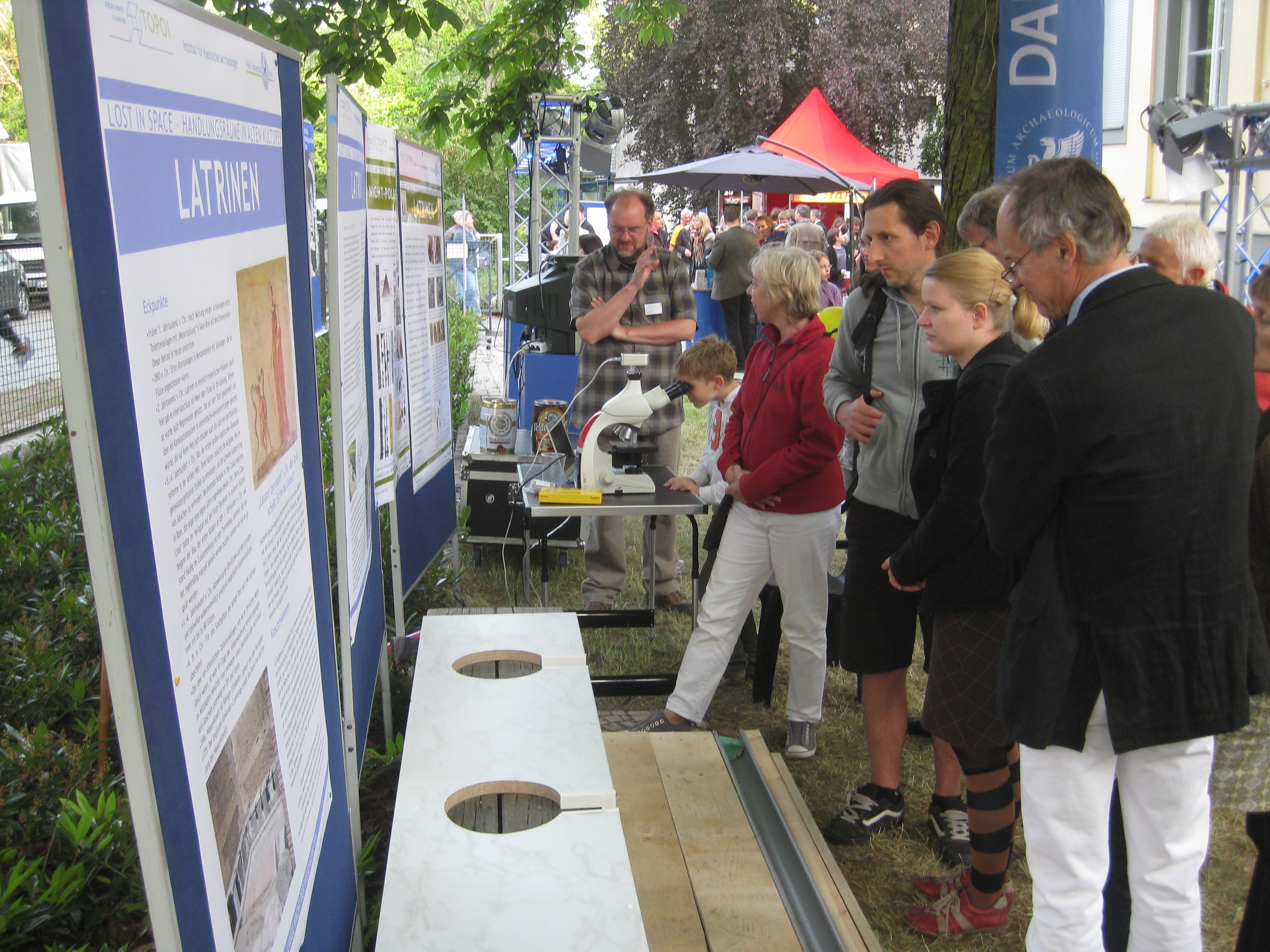 Latrine Besucher begutachten die römische Latrine | ©Topoi